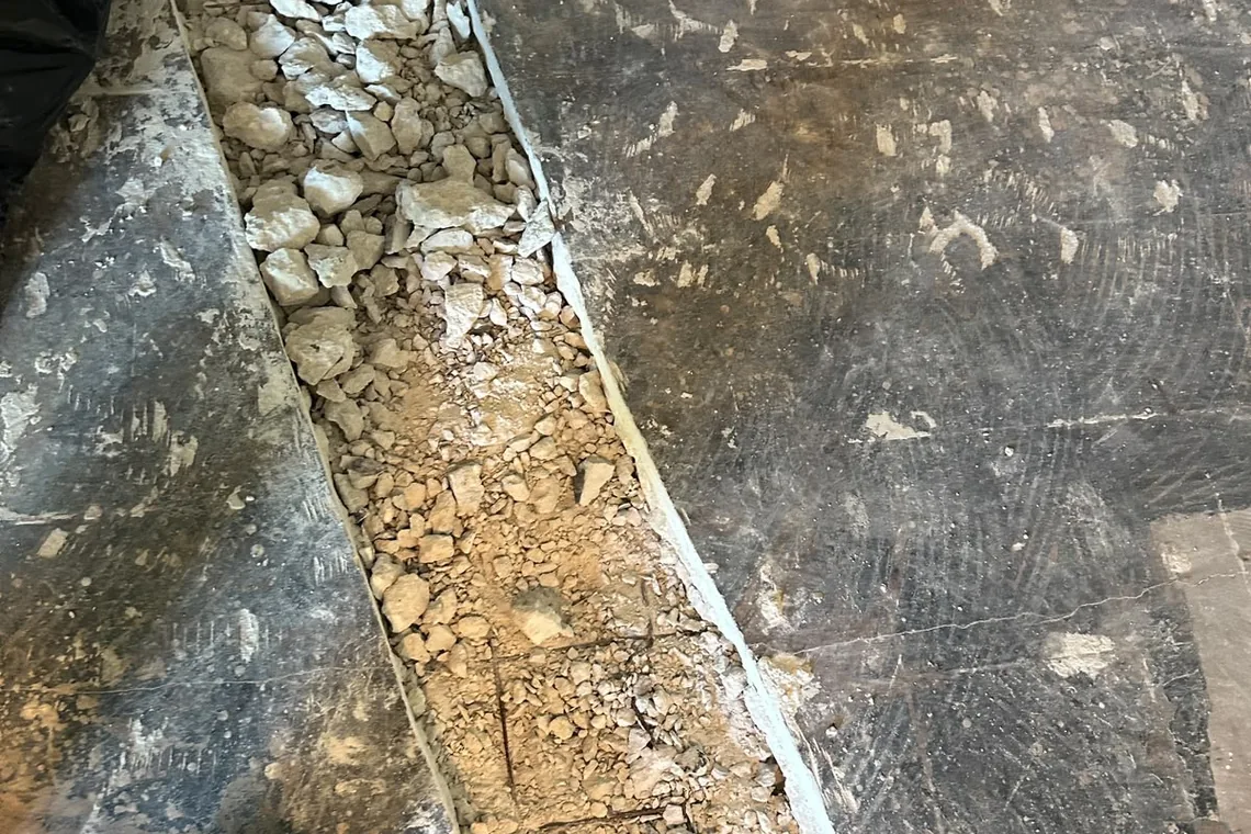 Open trench in a concrete slab for drain line replacement in Miramar